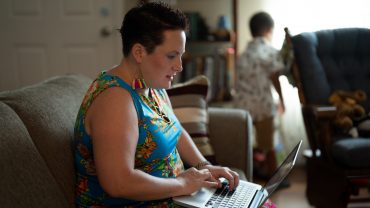 woman (Jen Ndegwa) types on a laptop