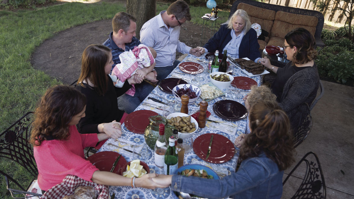 family praying before dinner.