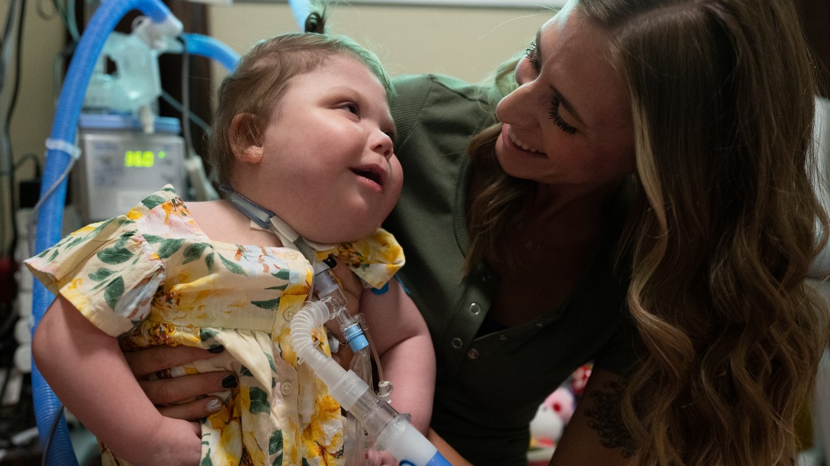 mom and young daughter smiling