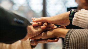 community of caregivers stacking hands