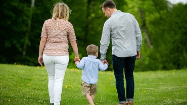 Woman, man, child holding hands