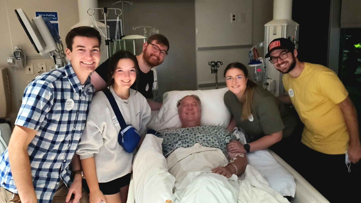 Man in hospital bed with family